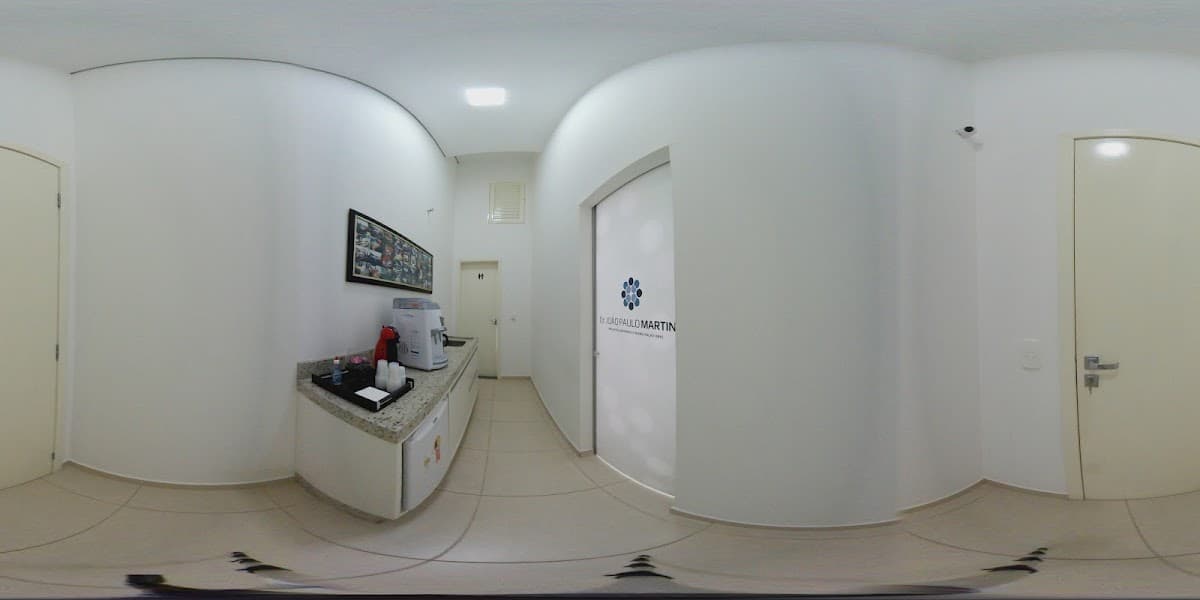 Vista do interior da clínica odontológica, com móveis e parede neutra.